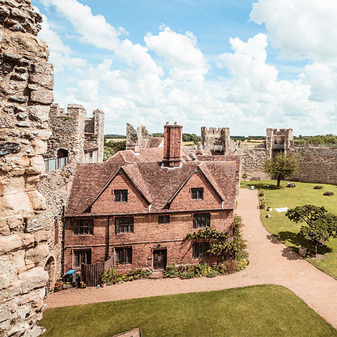 A red brick house surrounded by large castle walls at Framlingham Castle