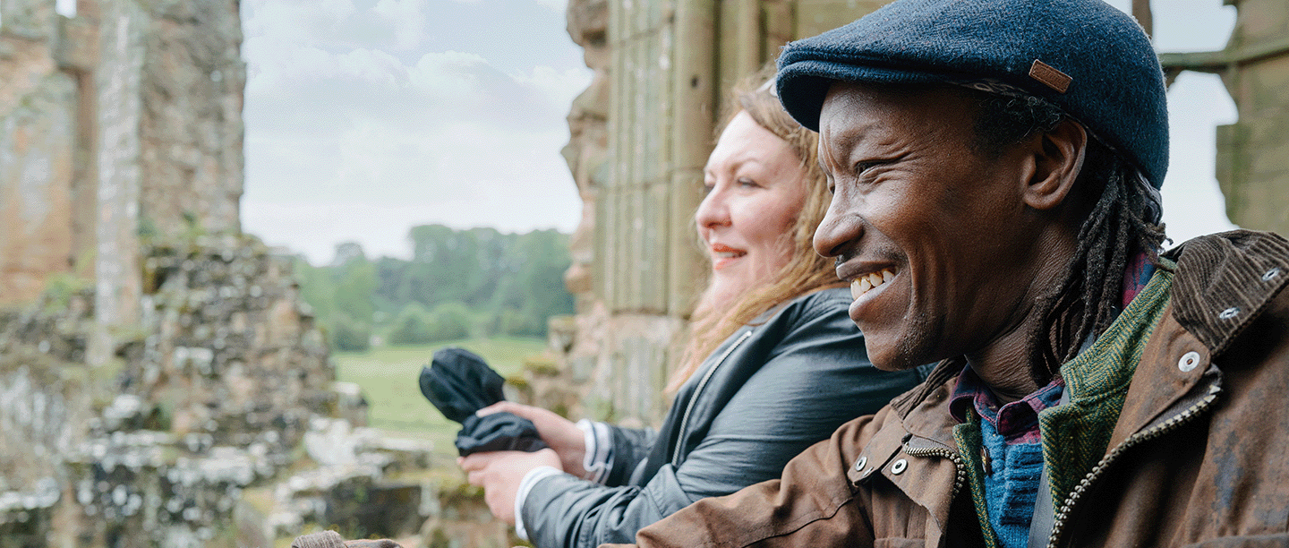Photo of two people looking at from the remains of Kenilworth Castle on a cloudy day